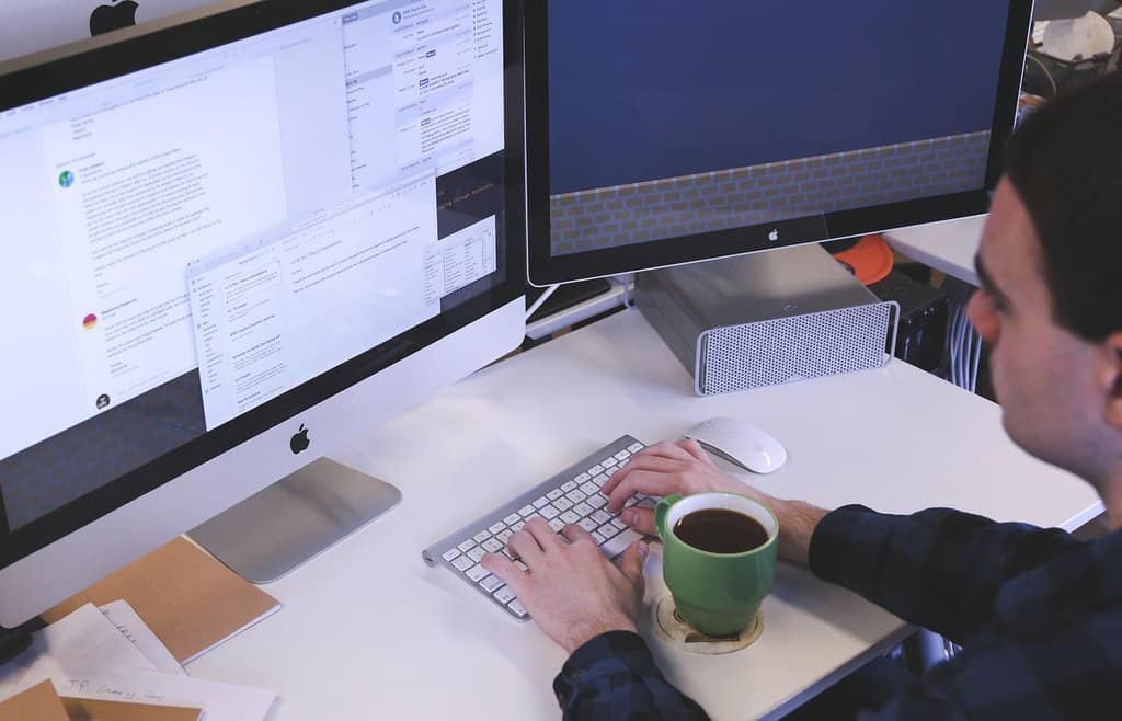 mężczyzna siedzący przy biurku i pracujacy na komputerze