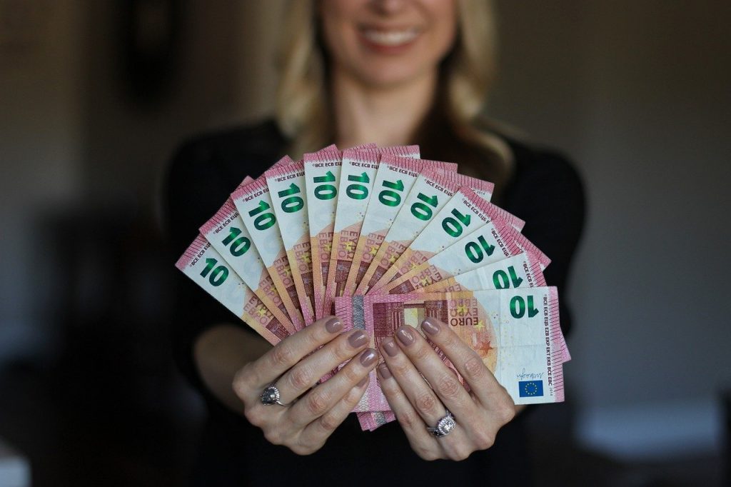 Kobieta trzymająca wahlarz banknotów