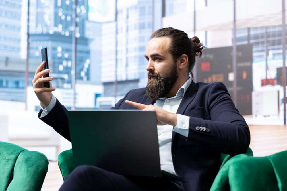Mężczyzna w garniturze z laptopem i telefonem